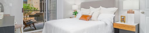 A bedroom with a large bed and a sliding glass door.