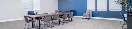 A conference room with a long table and chairs.