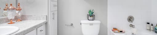 A white bathroom with a toilet, sink, and bathtub.
