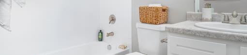 A white bathroom with a toilet, sink, and bathtub.