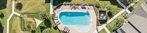 A bird's eye view of a neighborhood with a swimming pool and a small fountain.