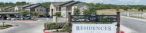 A sign for Residences at The Landing is displayed in front of a gated community.