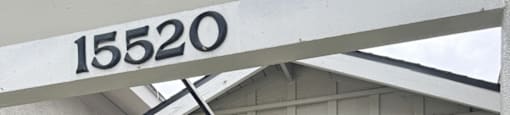 A black gate with a white sign that says 15520 on it.
