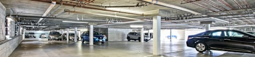 A parking garage with several cars parked.