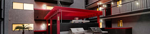 A modern outdoor kitchen area with a grill and seating area.