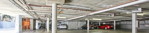 A parking garage with concrete pillars and a concrete ceiling.