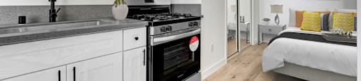 A modern kitchen with white cabinets and a stainless steel oven.