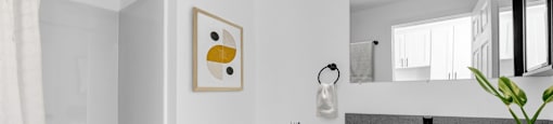 A white bathroom with a toilet, sink, and shower.