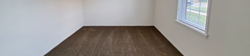 Bedroom in a 1 bedroom apartment with carpet and a window at Carriage House West.