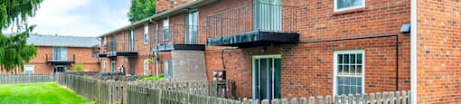 Exterior of an apartment building at Mount Vernon, featuring balconies and patios, surrounded by landscaped greenery.