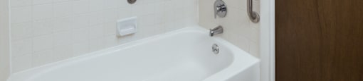 Bathroom with a tub head and hand held shower in a 1-bedroom, 1-bath senior apartment at Northwood Apartments in Franklin.