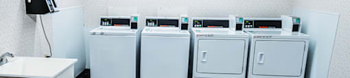 Laundry room in the elderly building at Carriage House Evansville, with washing machines and dryers.