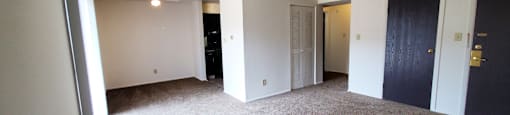 Living room with carpet and a door to a closet in a 1 bedroom apartment at Carriage House West.