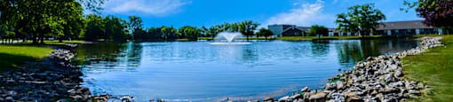 Pond at Carriage House Evansville, surrounded by greenery and calm waters.