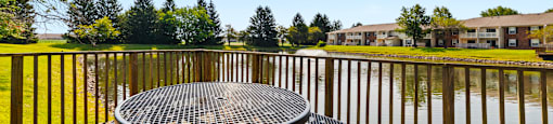 Water fountain in the pond at Fairington Apartments, Anderson, adjacent to a patio with seating overlooking the body of water.