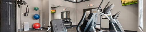 a gym with exercise equipment and ceiling fans