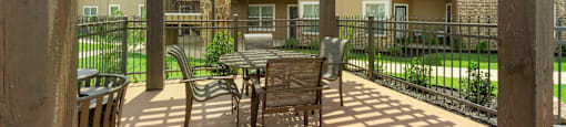 a covered patio with a table and chairs