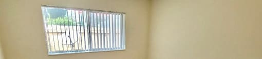 bedroom with plush carpeting and window with vertical blinds