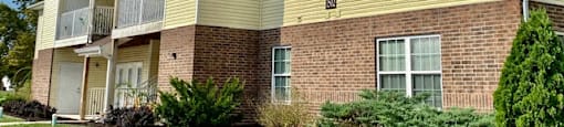 brick and yellow siding exterior of marion green apartments