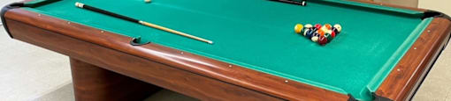 pool table with plenty of cues, bar stools, and water fountain