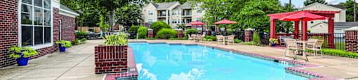 A pool surrounded by a red fence and a red gazebo.