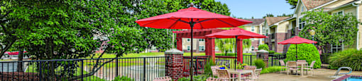 A poolside area with chairs and umbrellas.