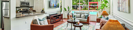 A living room with a couch, chairs, and a rug.