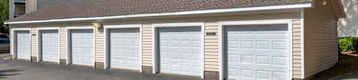 Detached Garages Next to Parking Lot with Trees in the Background