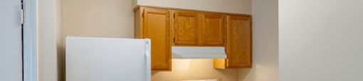 Kitchen with Blonde Cabinets Tan Counters and White Appliances