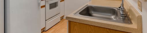 Kitchen with Blonde Cabinets Tan Counters and White Appliances