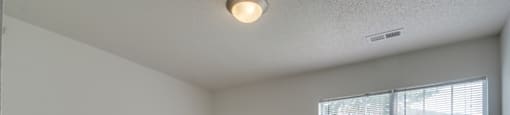 The bedroom has wall to wall carpet and a large picture window.