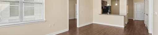 A large empty room with wooden floors and white walls.