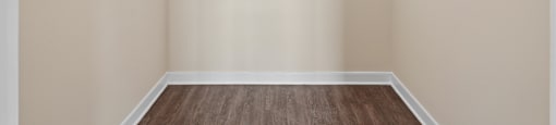 Empty room with white walls and wooden floor.