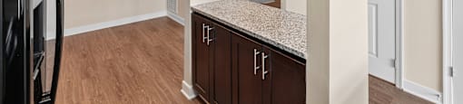 A kitchen with brown cabinets and a black refrigerator.