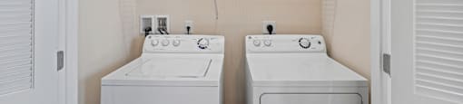A small laundry room with a washer and dryer.