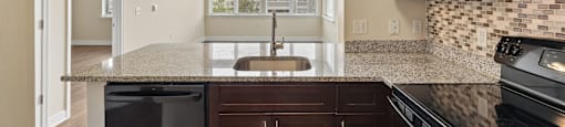 A kitchen with brown cabinets and a black stove top oven.