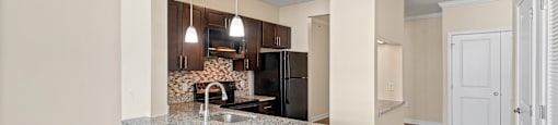 A kitchen with a granite countertop and a refrigerator.