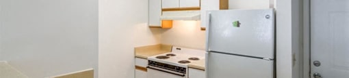 Kitchen with Wood Cabinet and White Cabinet and White Appliances Faces