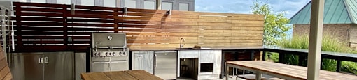a patio with tables and chairs and a grill