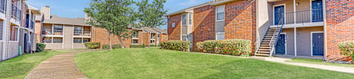 Courtyard with walking paths and green lawn at Towne Centre Village Apartments, Mesquite, Texas