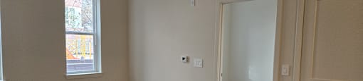 A room with a wooden floor and a door on the right.