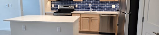 A kitchen with a white counter top and black appliances.