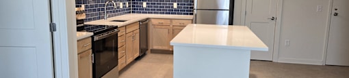 A kitchen with a white island in the middle.