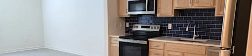 A kitchen with a stove, oven, microwave, and refrigerator.