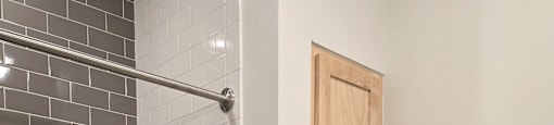 A white bathtub sits next to a wooden cabinet in a bathroom.