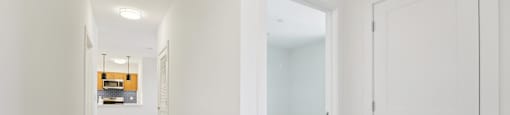 A long white hallway with a door on the right.