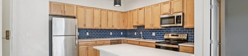 A kitchen with wooden cabinets and a white island.