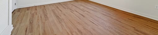 A room with wooden flooring and a window.