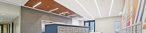 A long hallway with a blue wall and a row of mailboxes.