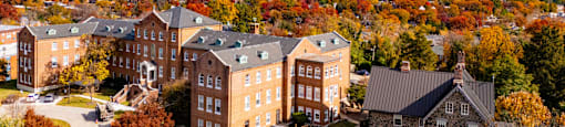 A large building complex surrounded by trees with autumn leaves.